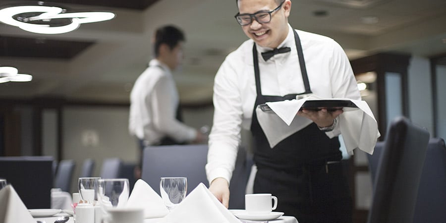 VCC student setting table at a restaurant