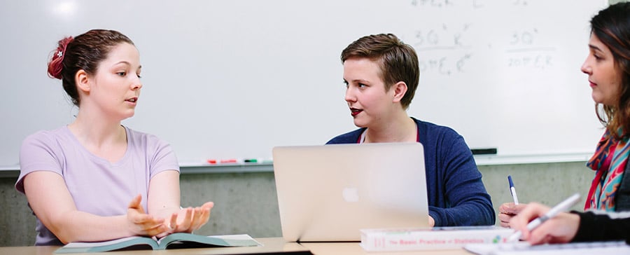 Students sitting at table with laptops