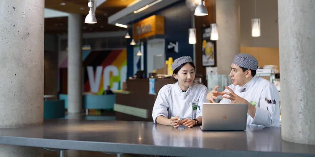 Culinary students engaged in a discussion in front of Blenz coffee shop