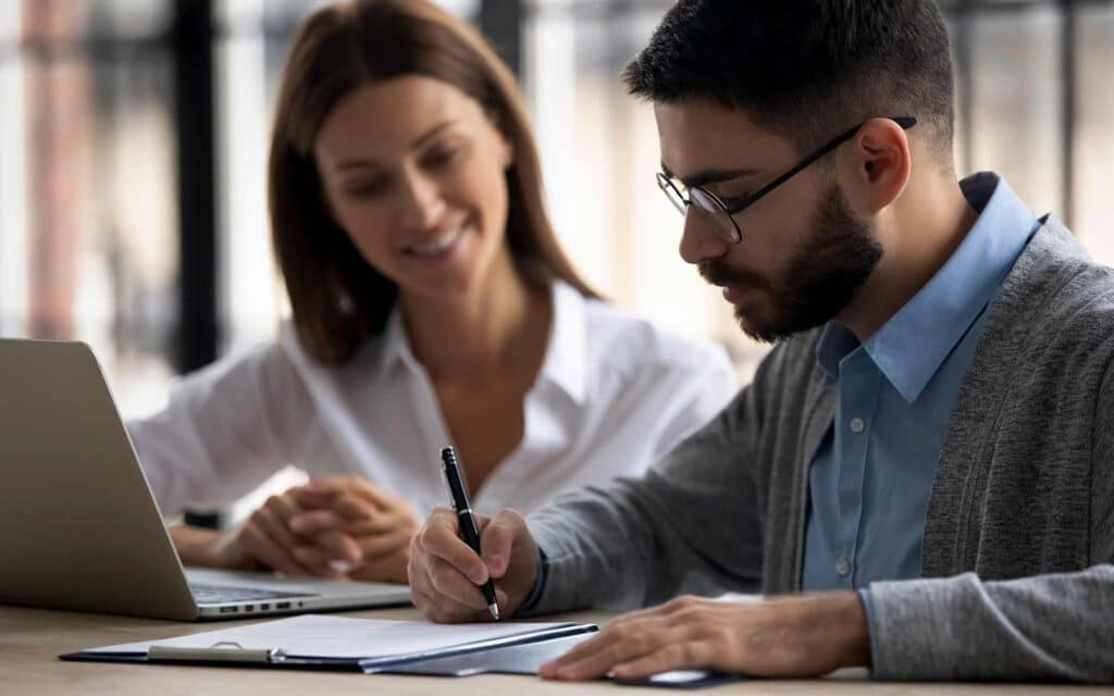 A staff helping a student with a document.