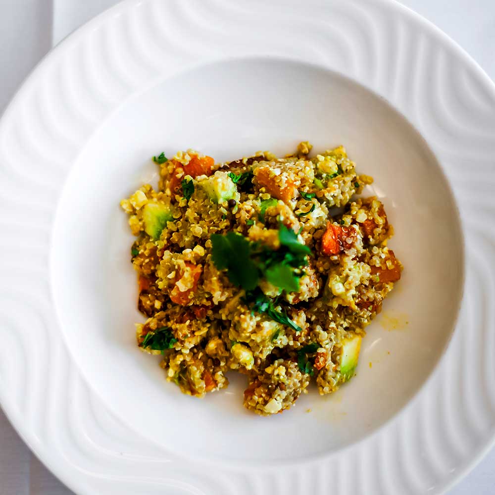 A vibrant grain salad mixed with roasted squash, fresh avocado, and herbs.