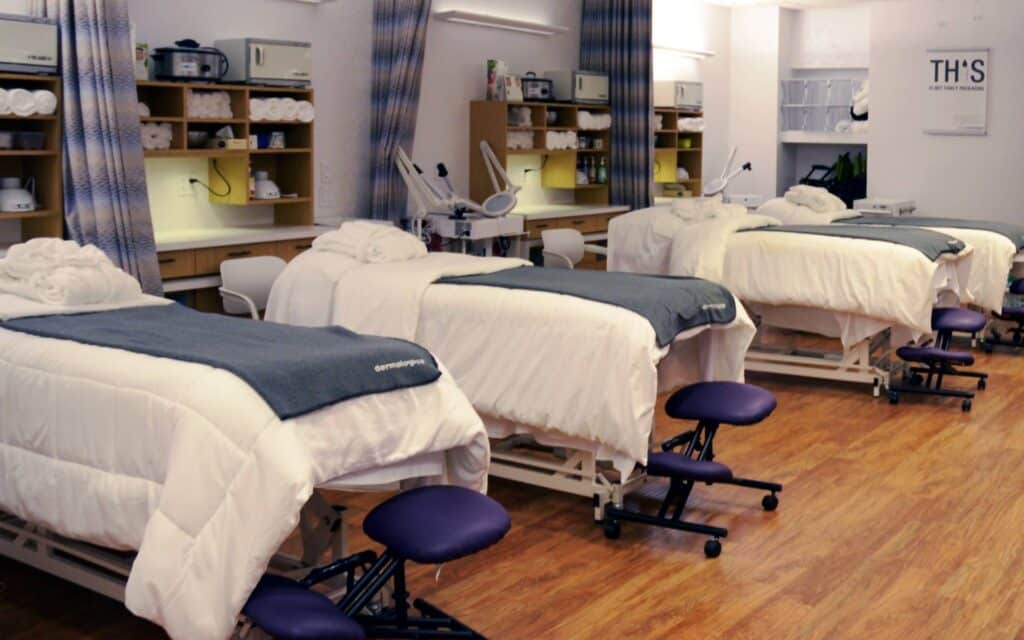 Multiple white spa treatment beds organized in a clean, professional room.