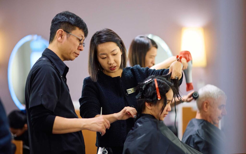 A hairstylist carefully trims a client's hair during a salon appointment.