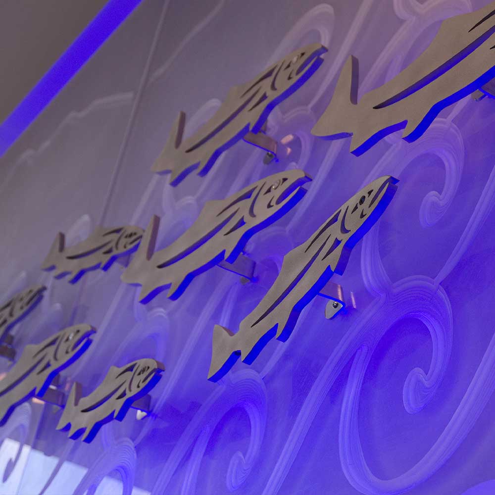 Indigenous art installation of salmon illuminated in blue lights
