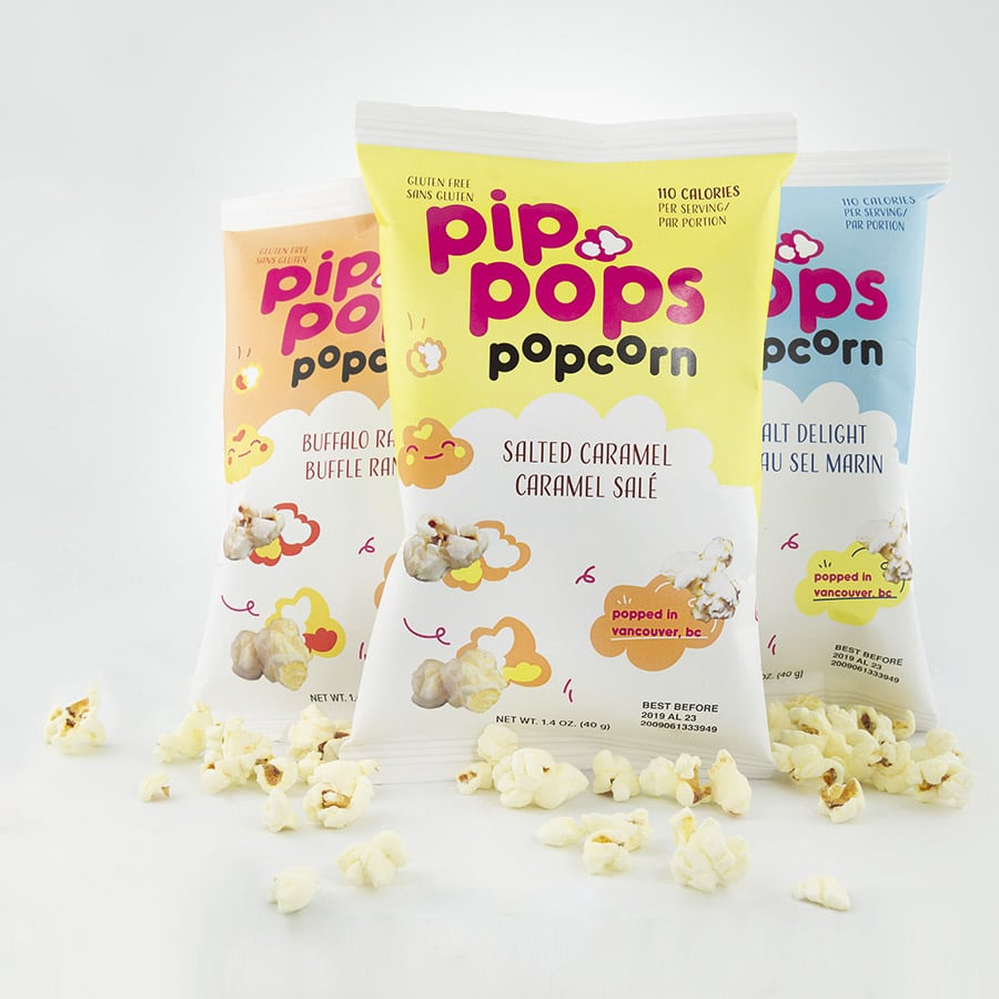 A vibrant display of three popcorn bags in yellow, orange, and blue, featuring playful typography and cloud-like graphics.