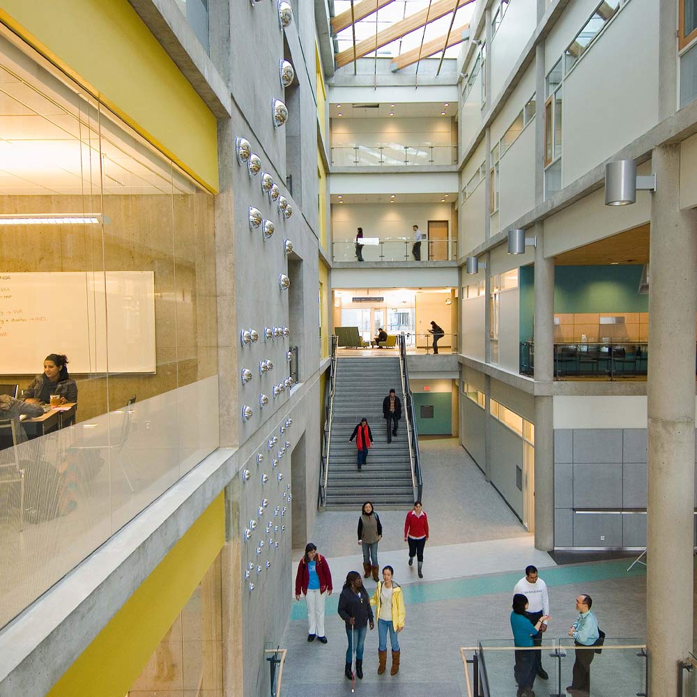 A bright, multi-level atrium features a central staircase and open-concept study balconies that encourage student interaction.