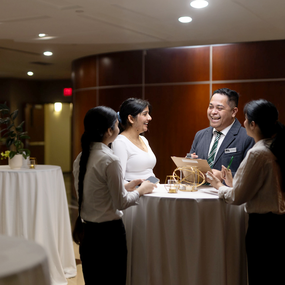 Hospitality program students discussing service tasks in a training restaurant