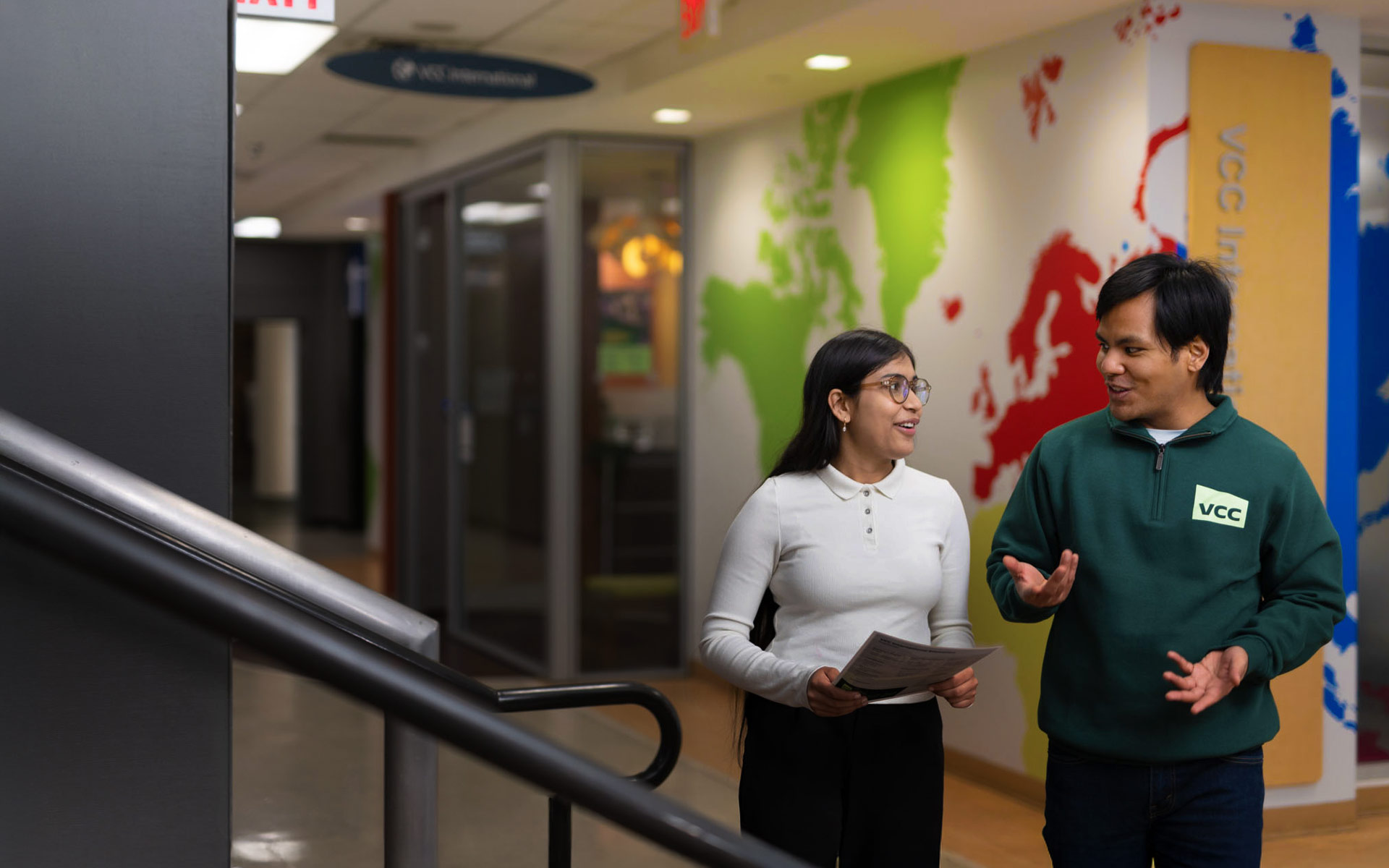 Two international students walking the halls of International Education office