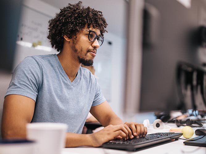 A student in classroom, in front of a computer